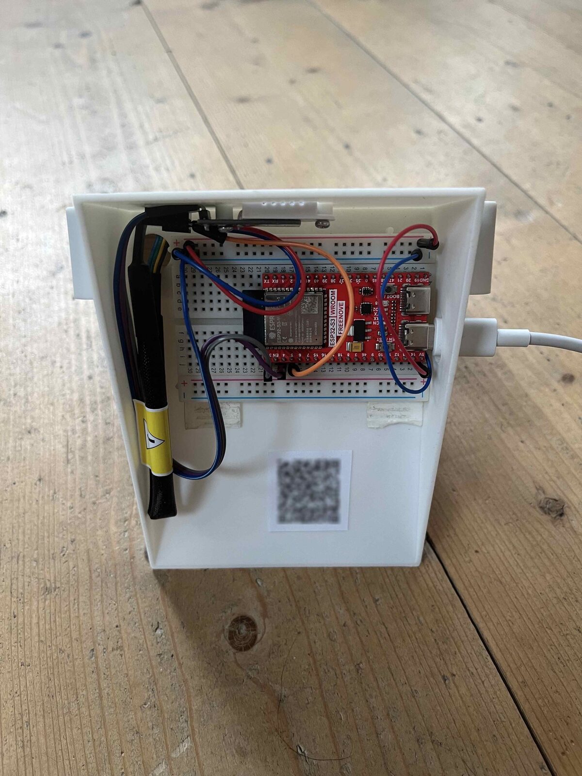 The ESP32 devkit on a breadboard, wired to the DHT22 sensor and an external antenna, mounted in the base of the 3D-printed enclosure